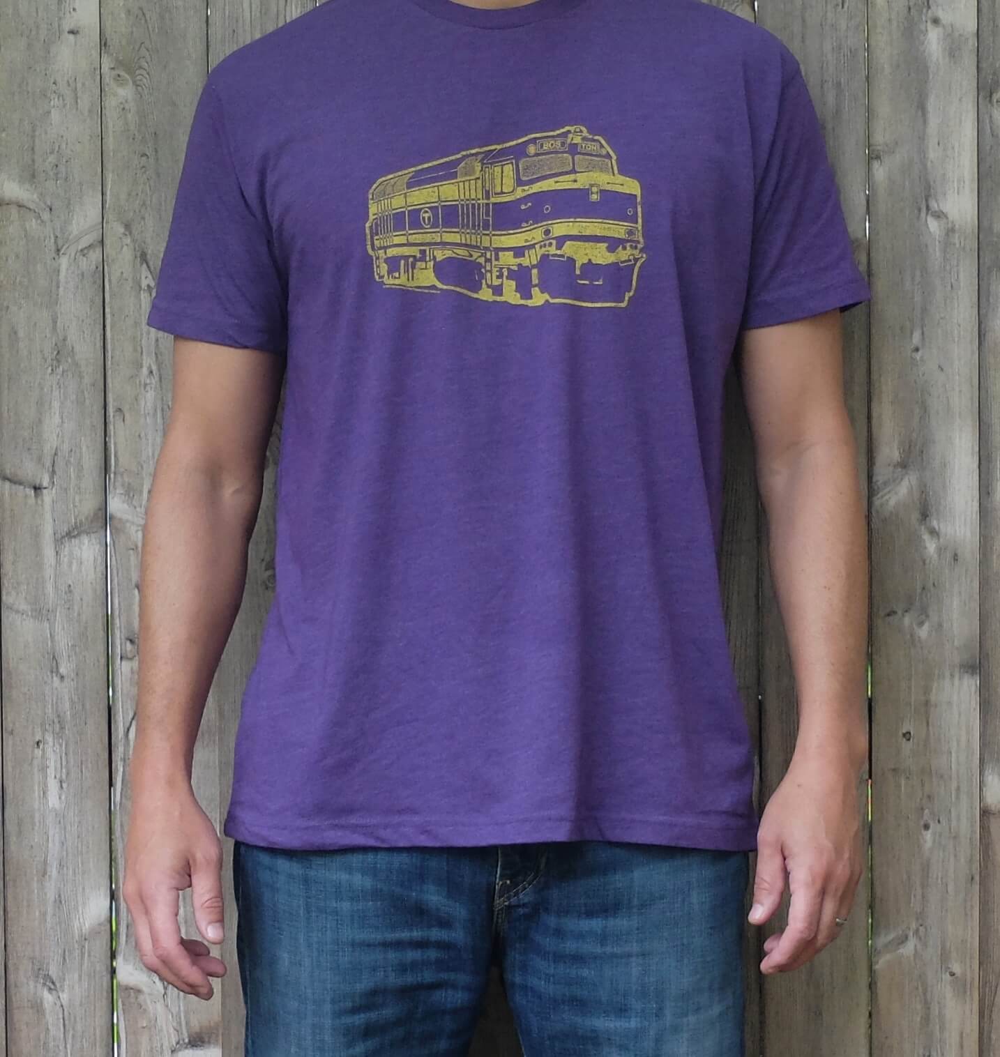 man wearing heather purple t-shirt with gold boston mbta commuter rail locomotive graphic